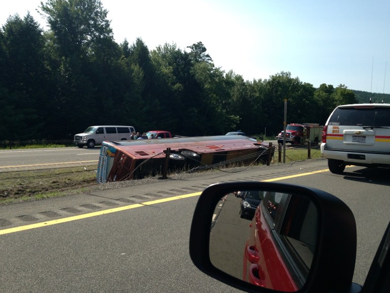 A Canadian tour bus carrying 54 people from Quebec City to New York City rests on its side after rolling over on the Northway in the Adirondacks in Essex County, N.Y., Friday, July 18, 2014. New York state police spokeswoman Darcy Wells had no word on possible injuries or deaths. (AP Photo/Adirondack Daily Enterprise, Catherine Moore)