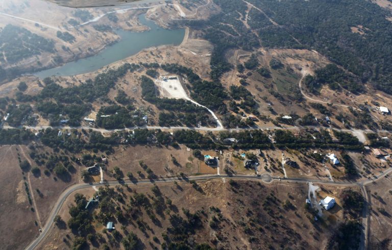 This Dec. 6, 2012 aerial photo shows a natural gas well, top center, drilled by Range Resources, but now operated by another company, near homes in rural Parker County near Granbury, Texas. (AP Photo/LM Otero)