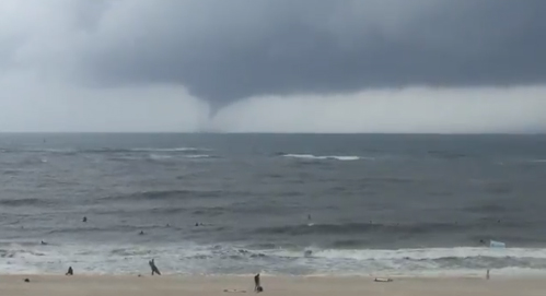Videos posted to Twitter show appeared to show the waterspout stretching down from the clouds over the water near Orange Beach. (Screen shot)