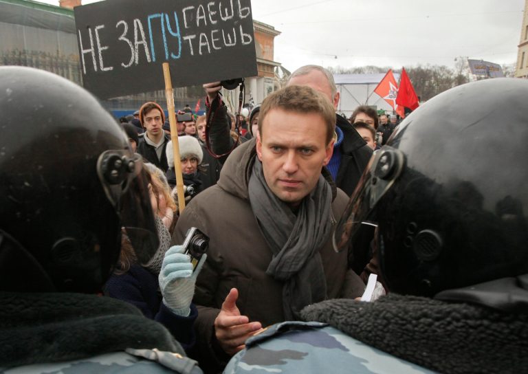   FILE - In this file photo taken on Saturday, Feb. 25, 2012, Opposition leader Alexey Navalny, speaks with riot police officers blocking the way during a massive protest rally against Prime Minister Vladimir Putin's rule in St. Petersburg, Russia. The poster reads: 'We will not be frighten