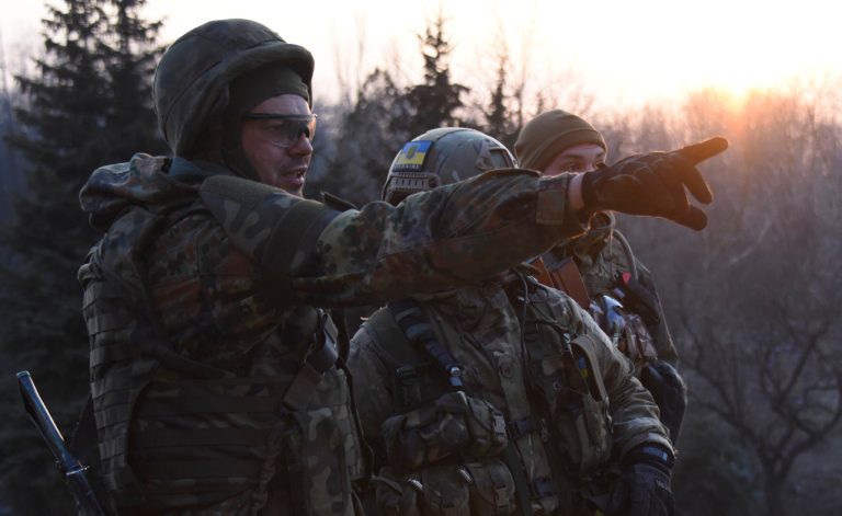 Fighters of the Azov Battalion observe enemy lines from the roof of their base in the town of Shyrokyne, eastern Ukraine, Sunday, March 22, 2015. (AP Photo)Â 