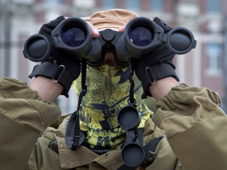 A Donetsk People's Republic fighter stands guard during a pro-Russian meeting in the city of Donetsk, eastern Ukraine Sunday, July 13, 2014. Pro-Russian insurgents last week retreated from the strategic city of Slovyansk and holed up in Donetsk, a city of one million, and potentially the final frontier for the rebels.  (AP Photo/Dmitry Lovetsky)