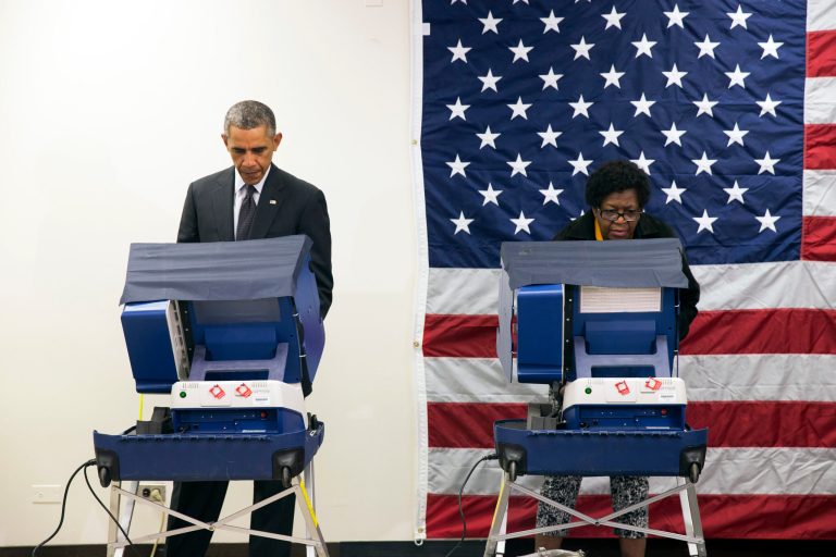 President Barack Obama, left, votes early for the midterm election at the Dr. Martin Luther King Community Service Center Monday, Oct. 20, 2014, in Chicago. Obama took a break from campaigning for Gov. Pat Quinn, D-Ill., to cast an early ballot for the election. (AP Photo/Evan Vucci)