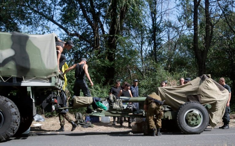 Ukrainian soldiers park their hardware on roadside as they are waiting for the start of the march into the town of Mariupol, eastern Ukraine, Wednesday, Aug. 27, 2014. Heavy shelling hit a town of Novoazovsk in southeastern Ukraine on Wednesday, the third day of an assault that has forced government troops to spread their ranks thinner along the Russian border. Ukraine claimed the shelling was coming both from pro-Russian separatists and from Russia itself. (AP Photo/Sergei Grits)