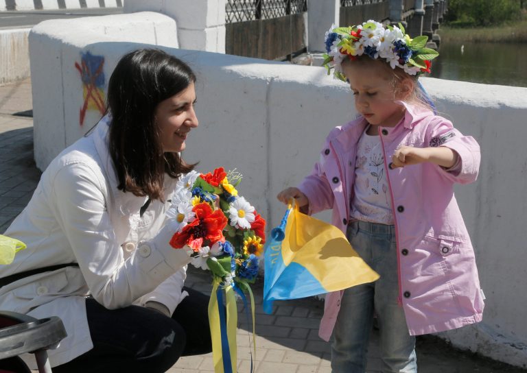 A child and her mother play with Ukrainian flag in Donetsk, Ukraine, Saturday. Members of the Group of Seven nations say they could move as early as upcoming Monday to impose additional economic sanctions on Russia in response to its actions in Ukraine. (AP Photo/Efrem Lukatsky)