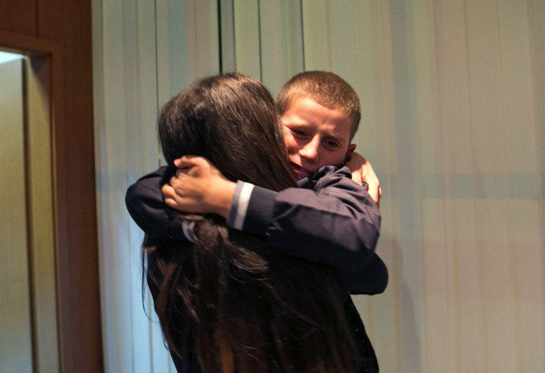 Pranvera Abazi kisses her son Erion Zena during their reunion at Kosovo's main airport upon his return to Kosovo's capital Pristina on Wednesday, Oct. 15, 2014. Kosovo's Prime Minister says the country's intelligence and security forces have returned an 8-year-old ethnic Albanian boy to his mother in Kosovo after he was taken by his jihadi father to Syria. (AP Photo/Visar Kryeziu)