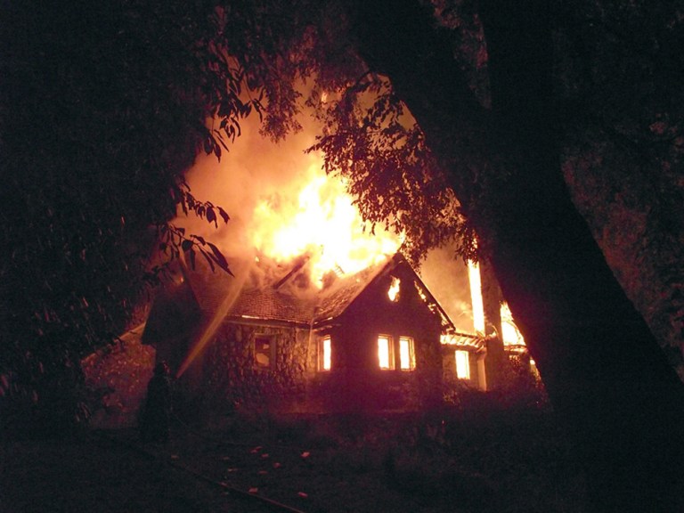 FILE - In this Jan. 4, 2013 file photo, a firefighter, left, works to extinguish the flames of the home of a non-Mapuche landowner in Vilcun, on the outskirts of Temuco, Chile. The elderly couple, Werner Luchsinger and wife Vivian Mackay, whose family's landholdings have long been targeted by Mapuche Indians in southern Chile, were killed in the arson attack while trying to defend their home. Celestino Cordova Transito, 27, who was shot in the neck during an arson attack was convicted on Thursday of killing the elderly couple in a region of southern Chile that the indigenous group claims as its ancestral territory.  (Hector Andrade/Agenciauno, File)