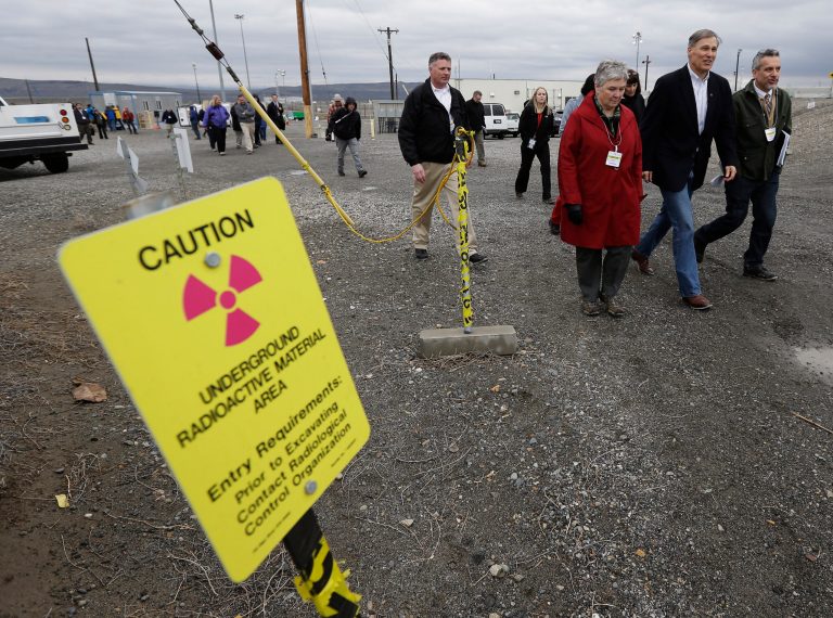 Washington Gov. Jay Inslee, second from right, walks near a sign warning of radiation, Wednesday, March 6, 2013, as he tours the C Tank Farm at Hanford Nuclear Reservation near Richland, Wash. Inslee was at Hanford to meet with Dept. of Energy officials in order to learn more about tanks on the site that are leaking radioactive waste. (AP Photo/Ted S. Warren)