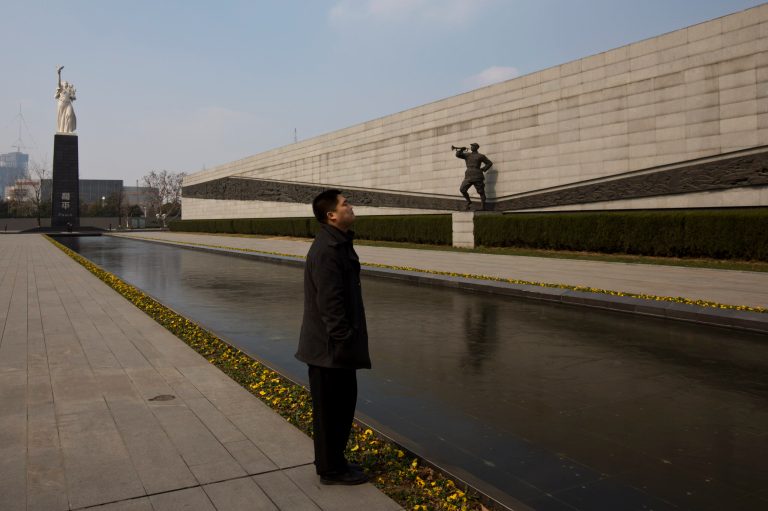 In this Feb. 11, 2014 photo, a visitor stands near sculptures at Nanjing Massacre Memorial Hall in Nanjing, in eastern China's Jiangsu province. The Tokyo shrine and the memorial hall in Nanjing, as Nanking is now called, are physical embodiments of divergent views of history that still strain China-Japan relations, 70 years after the war. They complicate America's objective of maintaining peace and stability in the Pacific, as President Barack Obama starts a 4-country Asian tour in Japan this week. The implications are potentially serious, particularly over contested uninhabited islands called the Senkaku by Japan and Diaoyu by China. (AP Photo/Alexander F. Yuan)