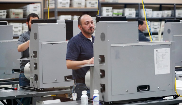 Employees at the Broward County Supervisor of Elections office clean machines during a break in sorting and counting of ballots during a recount, Wednesday, Nov. 14, 2018, in Lauderhill, Fla.