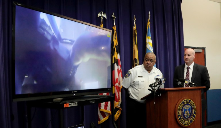 Baltimore Police Commissioner Michael Harrison, center, and Capt. Donald Diehl look on as the department makes public portions of footage from a body camera. 