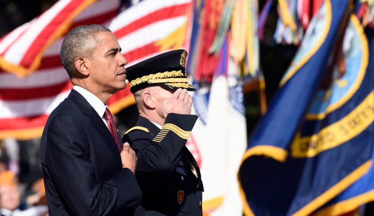 President Barack Obama, accompanied by Maj. Gen. Bradley A. Becker, Commanding General , U.S Army Military District of Washington, listens to the National Anthem after laying a wreath at the Tomb of the Unknowns, Wednesday, Nov. 11, 2015, at Arlington National Cemetery in Arlington, Va. during Veterans Day ceremonies. AP Photo/Susan Walsh