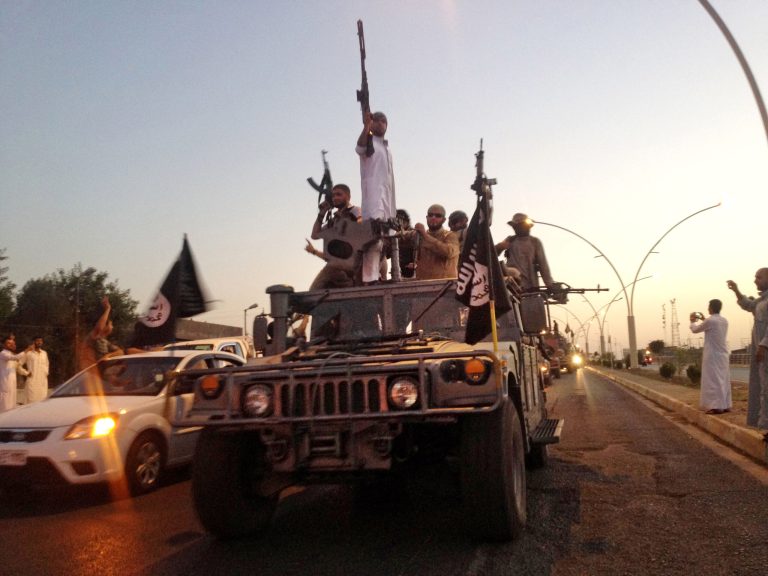 In this June 23, 2014, file photo, fighters from the Islamic State group parade in a commandeered Iraqi security forces armored vehicle down a main road at the northern city of Mosul, Iraq. (AP Photo/File)
