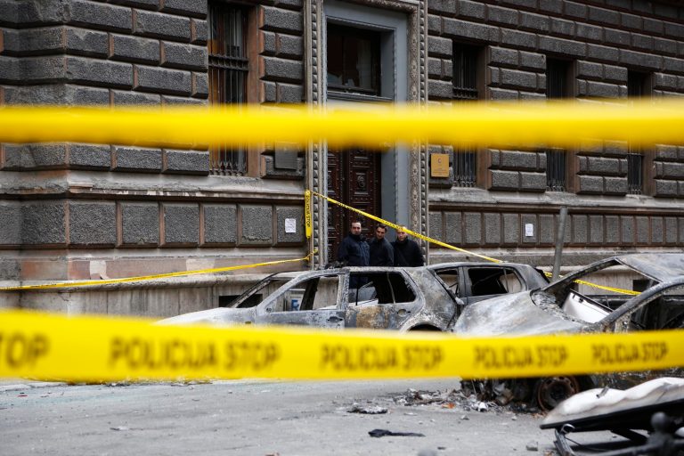 Bosnian workers look at burnt out cars in front of a burnt government building after protests in Bosnian capital of Sarajevo on Saturday, Feb. 8, 2014. Anti-government protesters have stormed into the Bosnian presidency and another government building in Sarajevo and set them ablaze as riot police fired tear gas in a desperate attempt to stop them. Smoke rose from several cities as thousands vented their fury over the Balkan nation's high unemployment and rampant corruption. (AP Photo/Amel Emric)