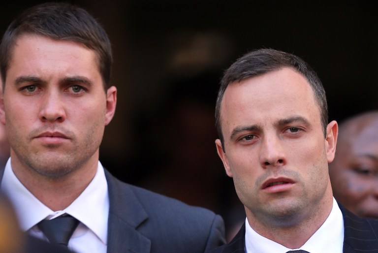 Oscar Pistorius, right, leaves the the high court in Pretoria, South Africa, Thursday, April 10, 2014. Pistorius is charged with murder for the shooting death of his girlfriend, Reeva Steenkamp, on Valentines Day in 2013. (AP Photo/Themba Hadebe)