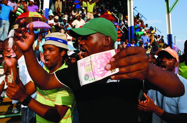 Miners sing and dance whilst holding South African bank notes in Lonmin Platinum Mine near Rustenburg, South Africa, Tuesday, Sept. 18, 2012. Striking miners have accepted a company offer of a 22% overall pay increase to end more than five weeks of crippling and bloody industrial action. (AP Photo/Themba Hadebe)