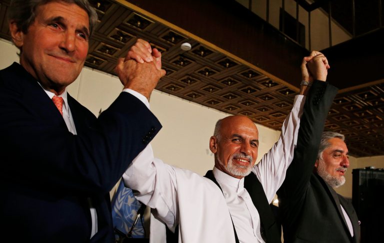 U.S. Secretary of State John Kerry, left, and Afghanistan's presidential candidates Ashraf Ghani, centre, and Abdulah Abdullah hold their arms in the air together after announcing a deal for the auditing of all Afghan election votes at the United Nations Compound in Kabul, Saturday, July 12, 2014.  (AP Photo/Jim Bourg, Pool)