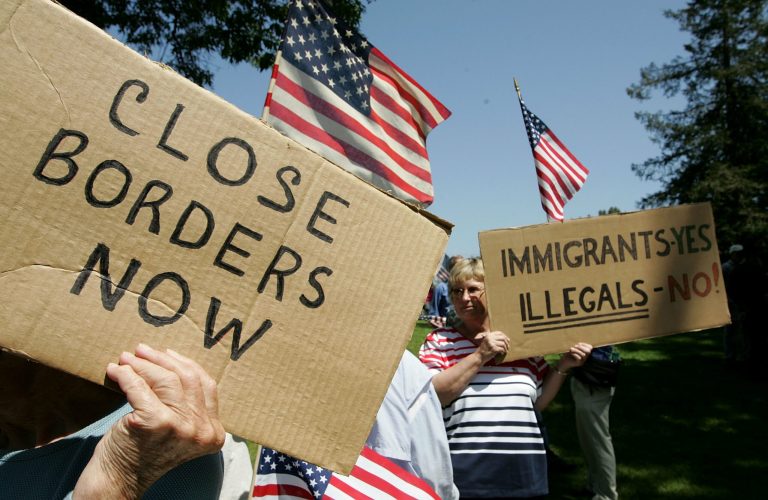Anti-immigration demonstrators hold signs and American flags during an anti-immigration rally May 5, 2006 in Santa Clara, California. (Photo by Justin Sullivan/Getty images)