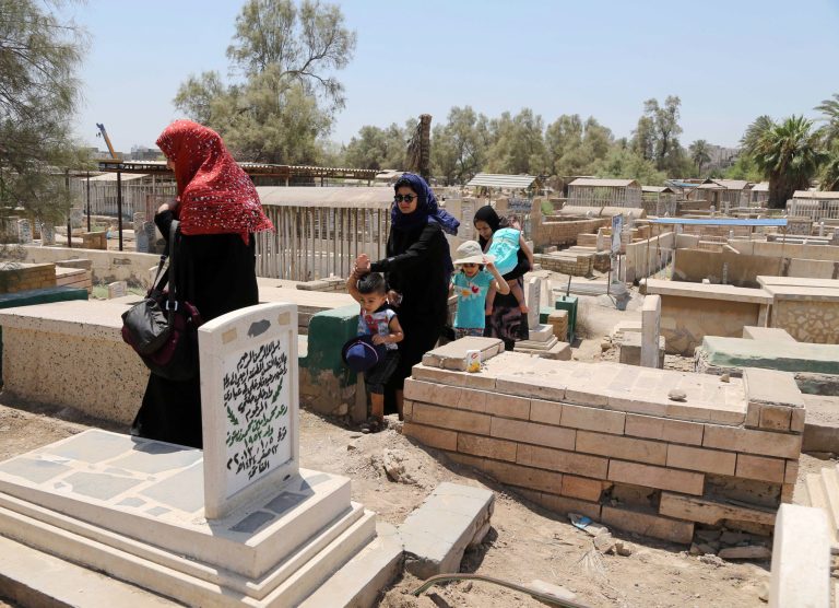 Iraqis visit the grave of a relative on the first day of Eid al-Fitr in Baghdad, Iraq, Monday, July 28, 2014. Monday marked the beginning of the three-day Eid al-Fitr holiday, which caps the Muslim fasting month of Ramadan. Muslims usually start the day by visiting cemeteries, to pay their respects to the dead, and then exchange family visits. (AP Photo/Karim Kadim)