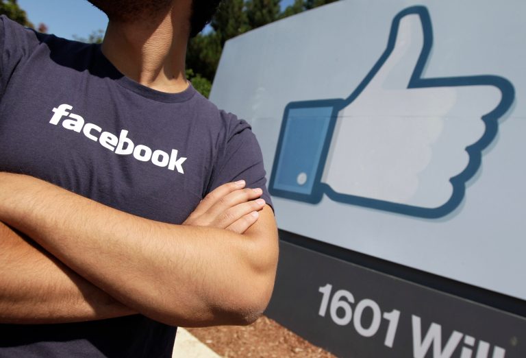 FILE - In this Aug. 17, 2012 file photo, a Facebook worker waits for friends to arrive outside of Facebook headquarters in Menlo Park, Calif. Facebook and Apple, long known for cushy perks such as free meals, laundry service and massages, are among some of Silicon Valley's biggest companies now eyeing reproductive expenses as the next batch of benefits to offer to their employees. (AP Photo/Paul Sakuma, File)