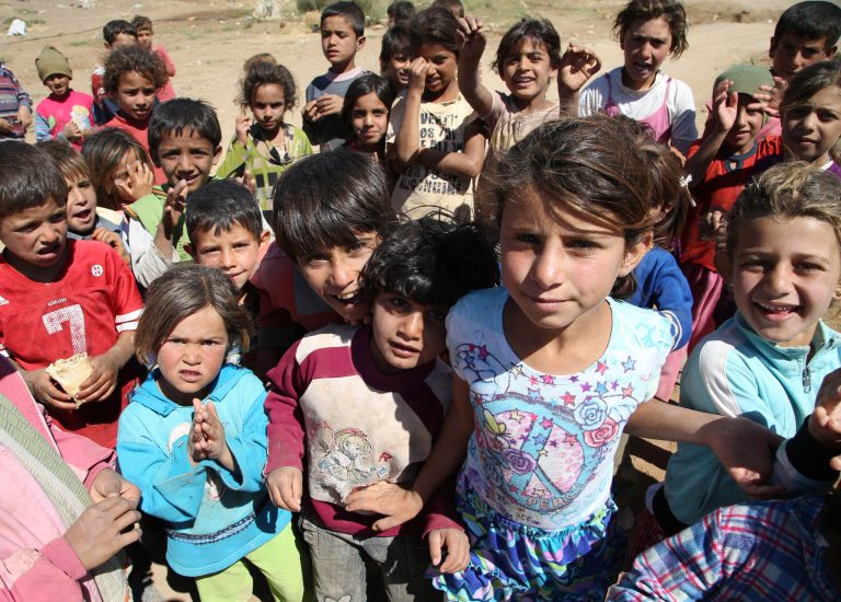 In this picture taken on Tuesday, Sept. 16, 2014, Displaced Syrian boys and girl gather at their refugee camp during the visit of the United Nations High Commissioner for Refugees (UNHCR) Antonio Guterres and U.N. Development Program Administrator Helen Clark, in Deir al-Ahmar village, near Baalbek city, east Lebanon. A report by the Britain-based Save the Children released Thursday, Sept. 18, 2014 says that nearly three million Syrian children are not attending school due to the war raging in their country. (AP Photo/Hussein Malla)