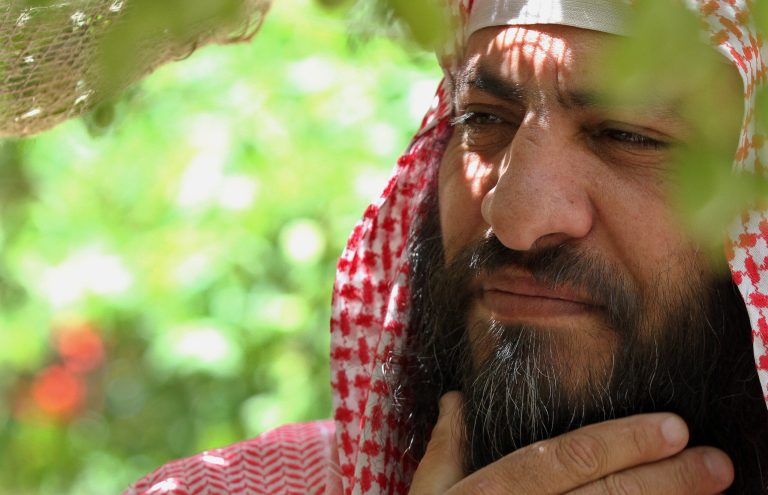 Senior Jordanian Salafi movement leader Mohammed al-Shalabi pauses during an interview with The Associated Press in the backyard of his house in Maan, 218 kilometers (135.5 miles) southwest of Amman, Jordan, Friday, July 4, 2014. Al-Shalabi, a Jordanian militant leader linked to al-Qaida, said Friday that the kingdom 