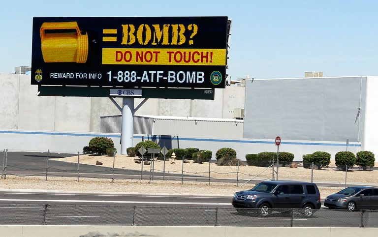   One of twenty public service announcement billboards on display across the Phoenix metro area along highways are warning citizens about picking up discarded flashlights Thursday, June 7, 2012, in Phoenix. In three separate incidents, unsuspecting bystanders picked up standard-looking yellow flashlights and flicked the switch to turn them on. But instead of lighting up as they should have, bombs that had been left inside the flashlights exploded in their hands. Five people in all received minor injuries, but authorities in the Phoenix area still have no idea who committed the bombings last month.(AP Photo/Ross D. Franklin)  