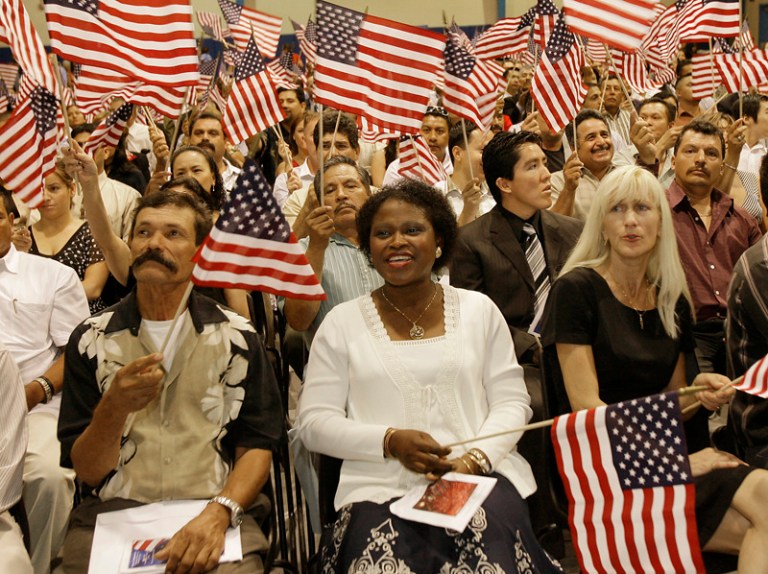 Pedro Solorzaro, of Mexico, Nola Davis, of Nigeria, and Hanna Simic, of Bosnia, from left, wave their flags during the 19th annual Fiesta of Independence after they were sworn in as new American citizens at South Mountain Community College,  Wednesday, July 4, 2007, in Phoenix. (AP/Ross D. Franklin)