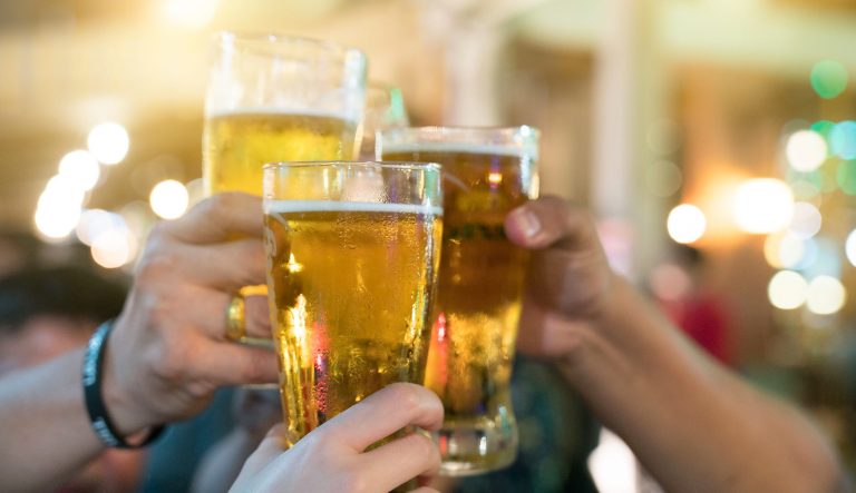 A group of friends celebrates over beer. 