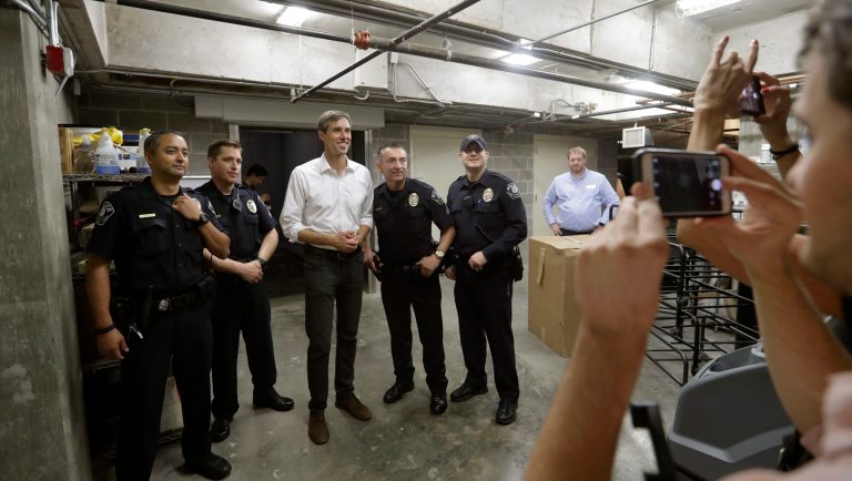 In this Tuesday, Oct. 2, 2018 photo, Democratic Senate candidate Rep. Beto O'Rourke, center in white shirt, poses for a photo with campus police following a campaign stop at Austin Community College Eastview, in Austin, Texas. O'Rourke has risen to national prominence on a workaday image that aligns closely with his politics but not his family's actual finances. 