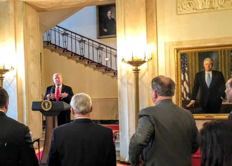 Trump’s favorite speaking perch is beside Clinton portrait