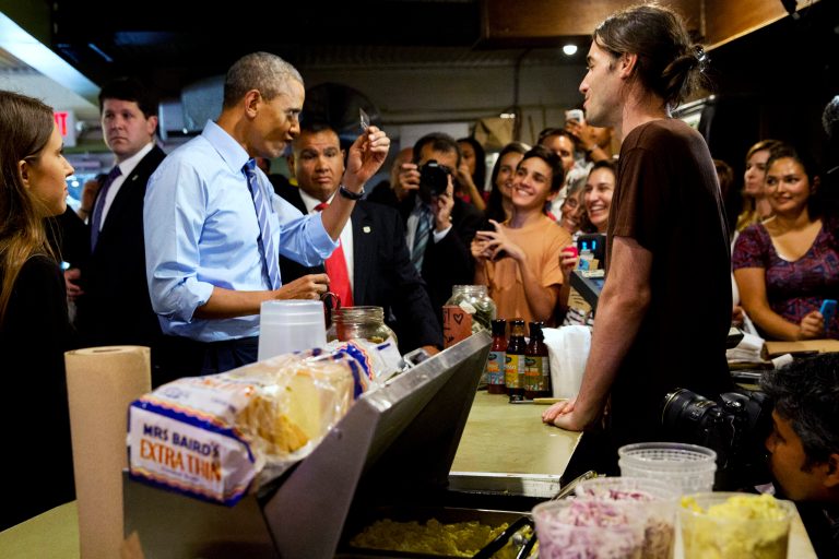 Never leave home without it: President Obama scrutinizes his credit card while ordering barbecue at Franklin Barbecue in Austin, Texas, Thursday. (AP Photo/Jacquelyn Martin)