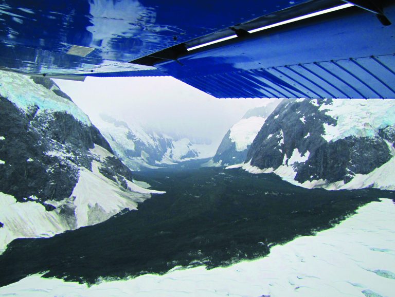 In this image provided by Drake Olson at flydrake.com, a landslide is seen at Glacier Bay National Park in Alaska on July 6, 2012. When a cliff collapsed in Glacier Bay National Park, it sent rock and ice coursing down a valley and over a lovely white glacier in what could be one of the largest landslide recorded in North America. The rumbling was enough so that it showed up as an earthquake in Alaska and Canada. (AP Photo/flydrake.com, Drake Olson)