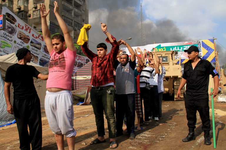 FILE - In this Wednesday, Aug. 14, 2013 file photo, Egyptian security forces detain protesters as they clear a sit-in by supporters of ousted Islamist President Mohammed Morsi in the eastern Nasr City district of Cairo.  On Tuesday, Aug. 12, 2014 the New-York based Human Rights Watch called for an international commission of inquiry into mass killings by Egyptian security forces last summer, saying they likely amount to crimes against humanity.  The report said that rather than investigating potential wrongdoing, the government has refused to acknowledge any possible infractions on the part of the security forces. (AP Photo/Ahmed Gomaa, File)