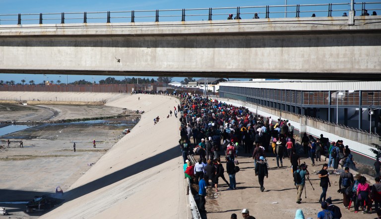 Central American migrants walk along the Tijuana River near the US and Mexico border in Tijuana, Mexico, on Sunday, Nov. 25, 2018. U.S. border officials temporarily closed the San Ysidro port of entry between Tijuana and San Diego, one of the busiest border crossings in the world, "to ensure public safety."