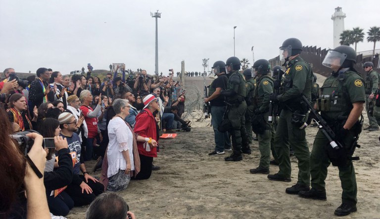 Religious leaders appear across from U.S. Border Patrol agents near the U.S.-Mexico border in San Diego.