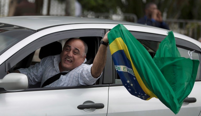 A supporter of Jair Bolsonaro salutes during a celebration in front of his residence after he was declared the winner of the election runoff, in Rio de Janeiro, Brazil, on Sunday. Bolsonaro, a brash far-right congressman whoâs expressed nostalgia for Brazil's old military dictatorship, won the presidency of Latin America's largest nation as voters looked past warnings that the former army captain would erode democracy. 