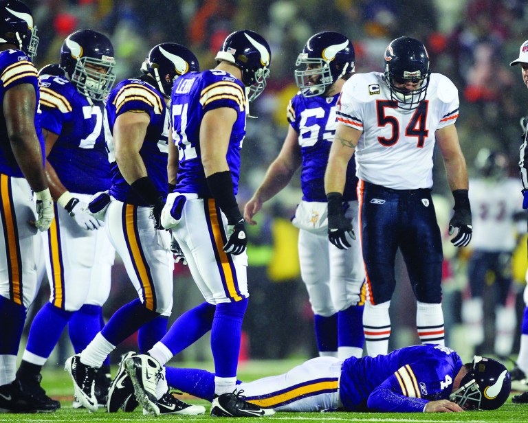 Chicago Bears' Brian Urlacher (54) looks down as Minnesota Vikings quarterback Brett Favre (4) lies on the ground after being hit during the first half an NFL football game in Minneapolis on Dec. 20, 2010.