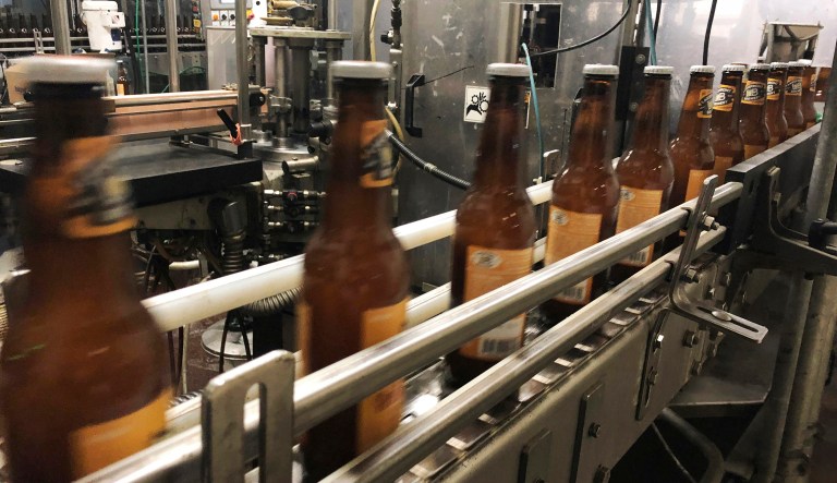 FILE- In this Jan. 14, 2019, file photo, bottles, freshly filled with beer, move on a belt at Lakefront Brewery in Milwaukee.