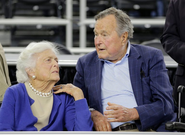 In this March 29, 2015, file photo, former President George H.W. Bush and his wife Barbara Bush, left, speak before a college basketball regional final game between Gonzaga and Duke, in the NCAA basketball tournament in Houston. Bush has fallen at home Wednesday, July 15, 2015, in Kennebunkport, Maine, and broken a bone in his neck. (AP Photo/David J. Phillip, File)