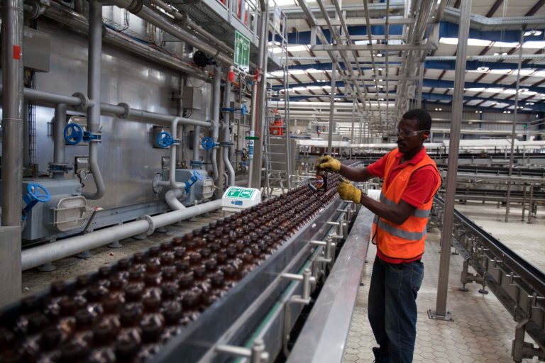 A worker cleans empty bottles of Prestige Beer at the Heineken/Brana Brewery S.A. in Port-au-Prince, Haiti, Friday April 4, 2014. Heineken NV says it is investing $100 million in the struggling Caribbean nation of Haiti. ( AP Photo/Dieu Nalio Chery)
