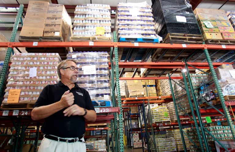 FILE- In this Monday, July 30, 2012 file photo, Dave Krepco, director of the Second Harvest Food Bank, checks on inventory at the food bank warehouse in Orlando, Fla. The Commerce Department reports on wholesale stockpiles and sales in July. The report will be issued Wednesday Sept. 10, 2014. (AP Photo/John Raoux, File)