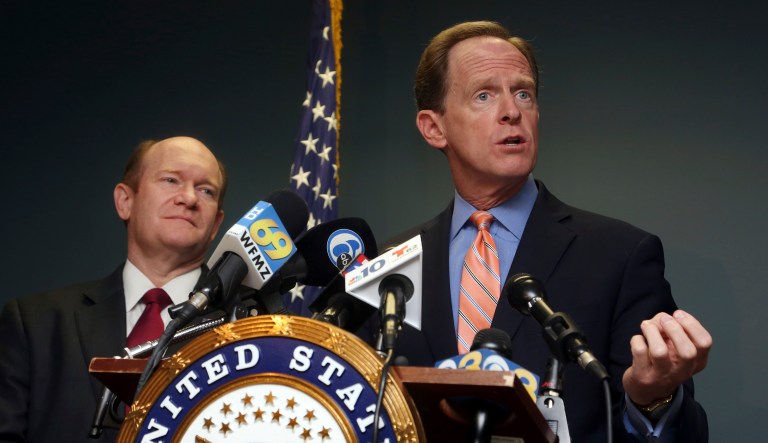 Sen. Pat Toomey, R-Pa., right, speaks during a press conference alongside Sen. Chris Coons, D-Del., on Monday in Philadelphia. Toomey and Coons say they have introduced a bill that will require federal authorities to notify states when a felon or a fugitive attempts to buy a firearm but fails the National Instant Criminal Background Check System. (AP Photo/Jacqueline Larma)