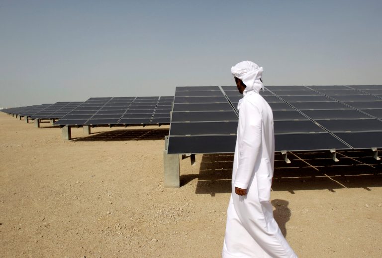   FILE - In theis Sunday, Jan. 16, 2011 file photo, an Emirati man pass by 10mw photovoltaic plant at Masdar City in Abu Dhabi, United Arab Emirates. The dean of a research institute at the core of Abu Dhabi's green-energy city said Sunday the government remains firmly committed to renewable power after recent shifts in the ambitious project's goals. Masdar City was originally conceived as a self-contained 