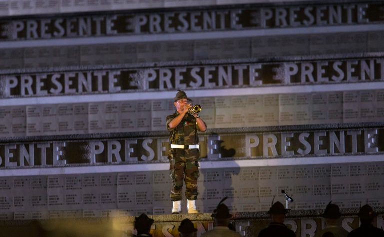 In this Sunday, July 6, 2014 file photo, an Italian Alpine soldier plays a homage with his trumpet to the fallen soldiers of World War I, ahead of a concert conducted by Riccardo Muti, commemorating the 100th anniversary of the outbreak of World War I at the Redipuglia memorial in Northeastern Italy.  The largest Italian war memorial, Redipuglia encases 100,000 Italian soldiers killed in battle, 60,000 of those whose identity remains unknown and 40,000 who are identified, sometimes with just an initial. (AP Photo/Paolo Giovannini, File)