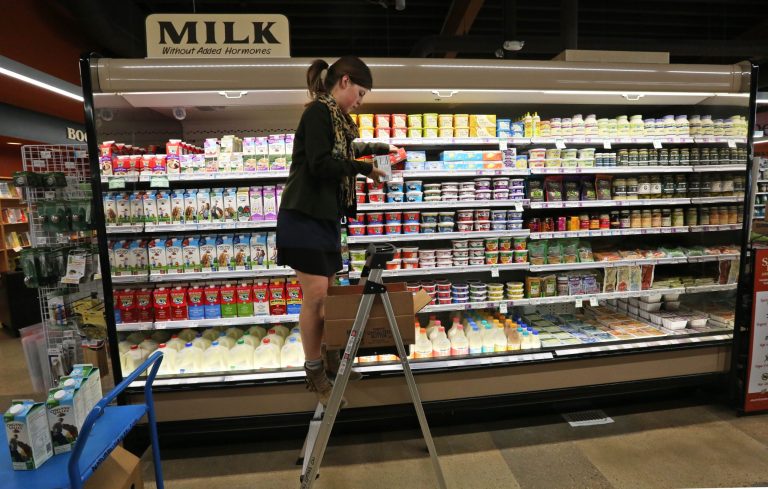 Grocery and dairy assistant Reyna DeLoge stocks dairy products that only use milk from pasture-raised cows, at Vitamin Cottage Natural Grocers, in Denver, Friday May 23, 2014. The Colorado-based grocery store chain recently announced that it will carry only dairy products from farms where cows graze on pasture, taking the position that grazing improves the health of cows and consumers. (AP Photo/Brennan Linsley)