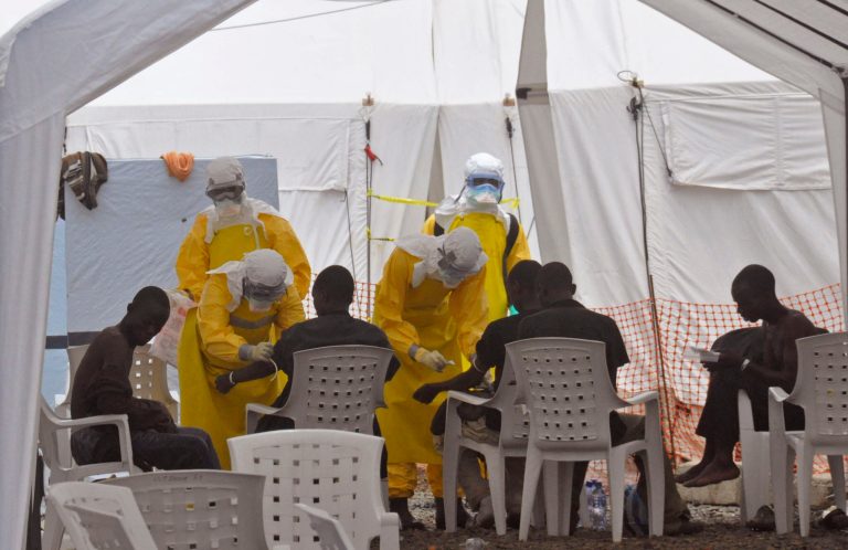 Health workers,  attend to patients that contracted the Ebola virus,  at a clinic  in Monrovia, Liberia, Monday, Sept. 8, 2014.  Border closures, flight bans and mass quarantines are creating a sense of siege in the West African countries affected by Ebola, officials at an emergency African Union meeting said Monday, as Senegal agreed to allow humanitarian aid pass through its closed borders. (AP Photo/Abbas Dulleh)