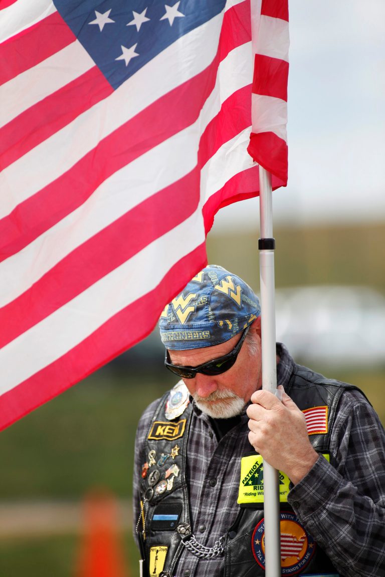Ken Helmbright, ride captain for the Patriot Guard, joins other members from Kentucky and W.Va. on Sunday, April 7, 2013, at Mingo Central High School in Matewan, W.Va. for a memorial for Mingo County Sheriff Eugene Crum who was gunned down after just three months in office. Rosie Crum, his wife, was sworn in as the new sheriff. (AP Photo/Randy Snyder)