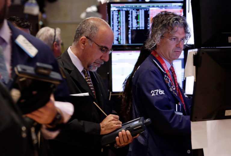 In this Monday, June 30, 2014 photo, trader John Liotti, center, and specialist Donald Civitanova, right, work on the floor of the New York Stock Exchange. World stocks were mostly higher Wednesday, July 2, 2014, on improved U.S. and Chinese economic activity. (AP Photo/Richard Drew)