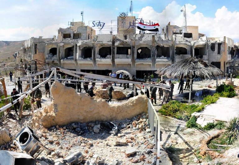 This Monday, April 14, 2014 photo, released by the Syrian official news agency SANA, shows Syrian government soldiers gathering outside a damaged hotel that Syrian rebels had been using, in Maaloula village, northeast of the capital Damascus, Syria. Syrian government troops seized two villages, one of them an ancient Christian hamlet, north of Damascus on Monday, as part of the military's relentless offensive along the rugged frontier with Lebanon, state media and activists said. (AP Photo/SANA)